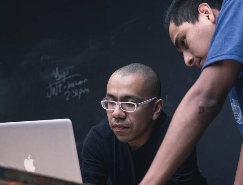 Academic Advisor discussing academic goals with a student while looking at a laptop