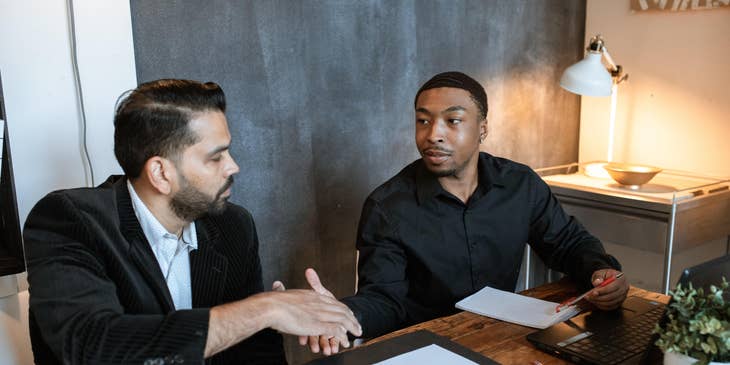 An Agency Manager doing a handshake with an employee.