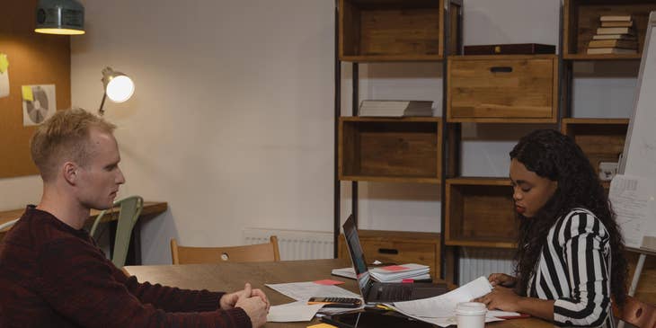 A Female Assistant Supervisor in an office setting in front of an employee.