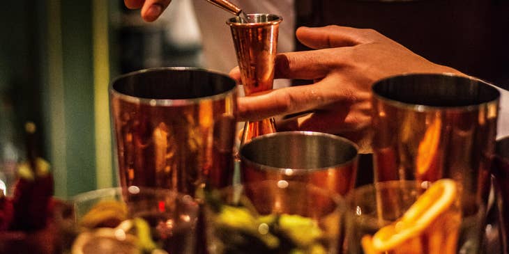 Bartender mixes alcoholic beverages as per customers request.