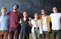 Empleados sonriendo mientras se hacen una foto de grupo.