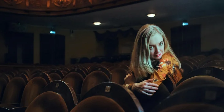 Une actrice assise dans un théâtre.
