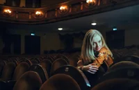 Une actrice assise dans un théâtre.