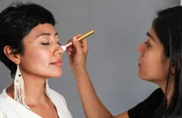 Une maquilleuse qui met du blush sur une cliente.