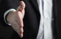 Un hombre haciendo una oferta de trabajo y extendiendo una mano.