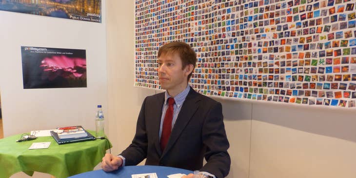 Un profesional de negocios sentado en una mesa en una feria de empleo.
