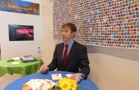 Un profesional de negocios sentado en una mesa en una feria de empleo.