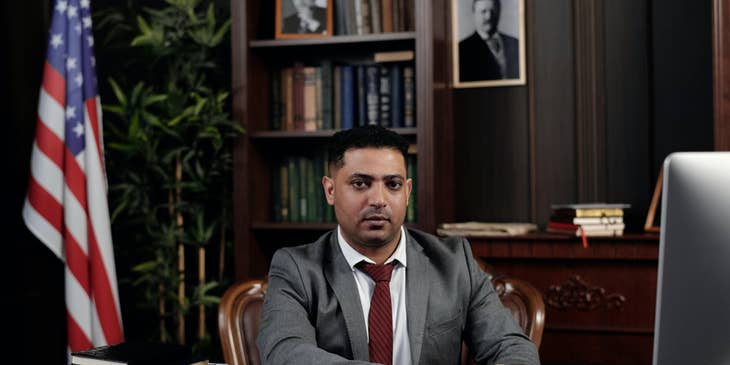 A Hispanic lawyer sitting at his desk.