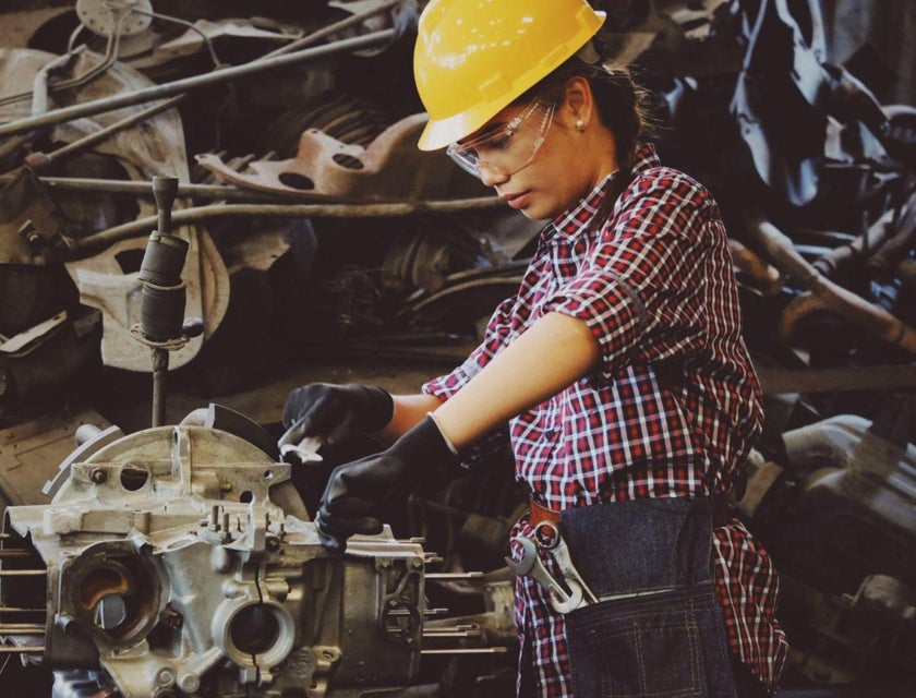 Una mujer trabajando en una fábrica automotriz contratada por una de las mejores bolsas de trabajo para mujeres.