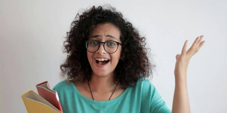 Una empleada disgustada levantando la voz con documentos en la mano.