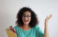 Una empleada disgustada levantando la voz con documentos en la mano.