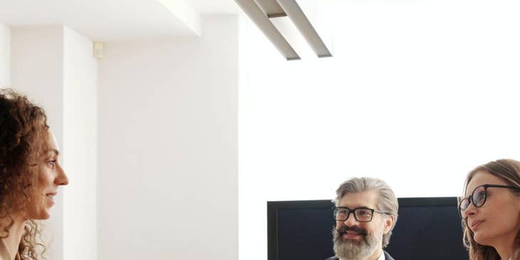 Personas sentadas en una entrevista de oficina durante un reclutamiento de ciclo de vida completo.
