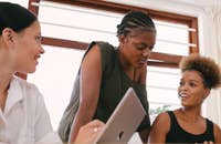 Un grupo de compañeros de trabajo discutiendo un proyecto en una empresa de adquisición de talento.