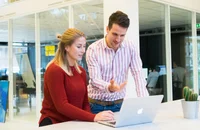 Un jefe hablando con su empleada a voluntad en una oficina.