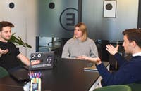 Un grupo de compañeros de trabajo discutiendo un proyecto de reclutamiento técnico alrededor de una mesa.