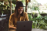 Un télétravailleur assis à une table devant son ordinateur.