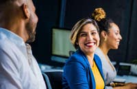 Tres colegas sentados juntos, sonriendo.