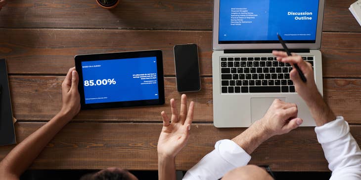 Business Advisor compares financial data to his team while working on strategies to improve business