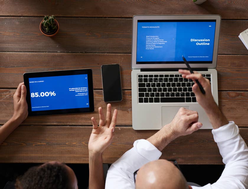 Business Advisor compares financial data to his team while working on strategies to improve business