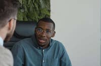 Un uomo a un colloquio a cui vengono chiesti i suoi punti forti e deboli.