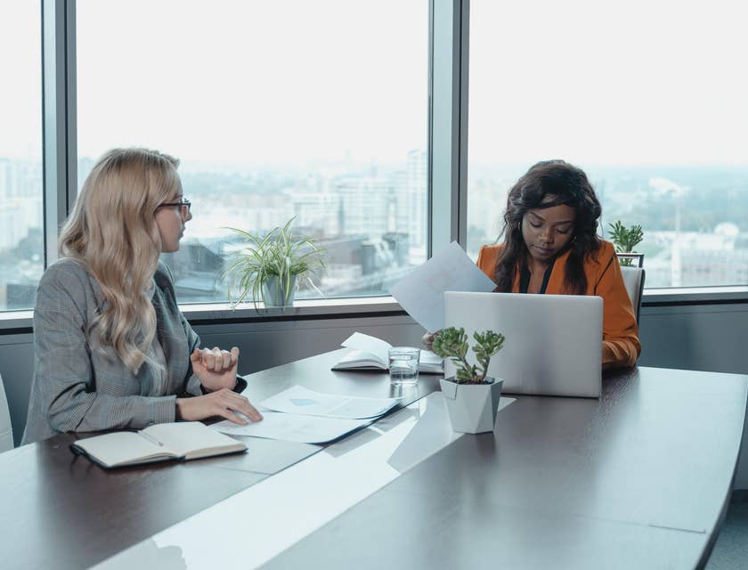 Development coordinator checking files while listening to colleague planning an event