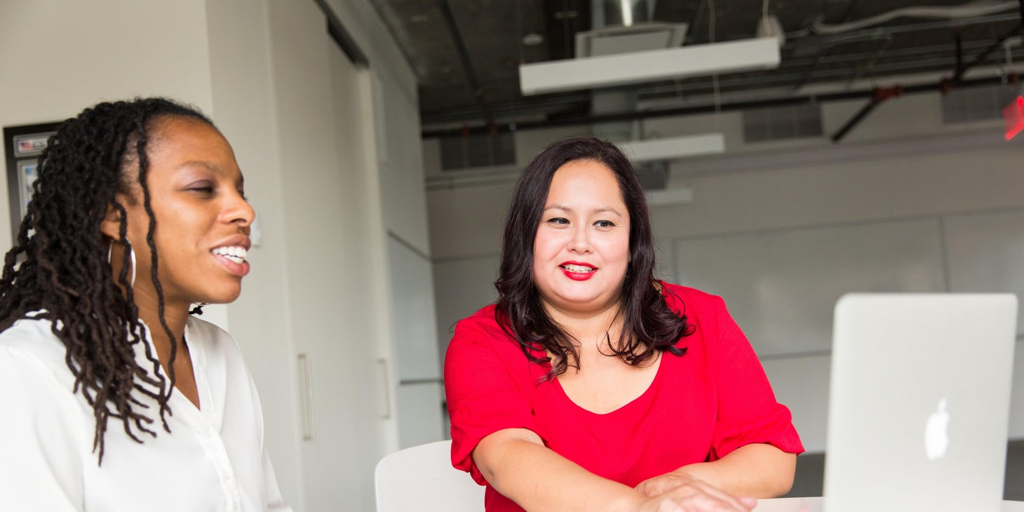 Education Director evaluates new teaching procedures to a teacher using a laptop