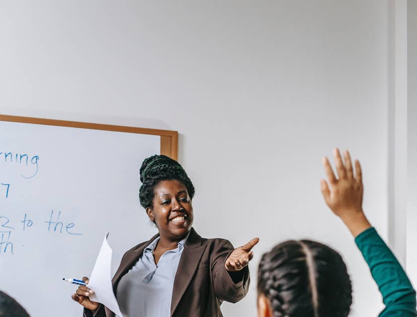 Elementary School Teacher calls out a student to answer questions written on the board