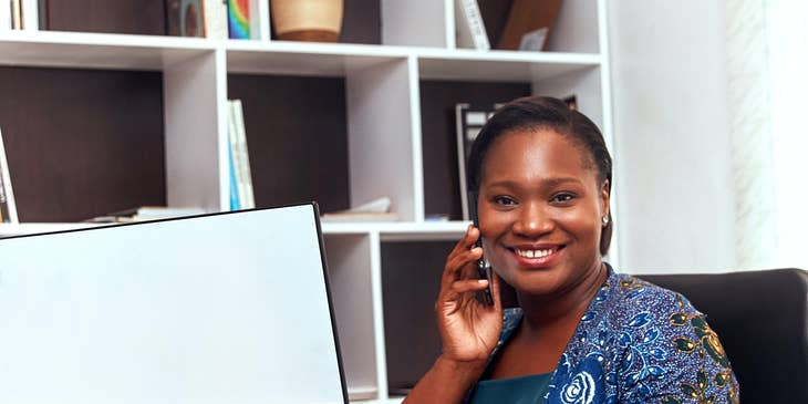 A Female Employee Relations Specialist in an office setting on her phone.
