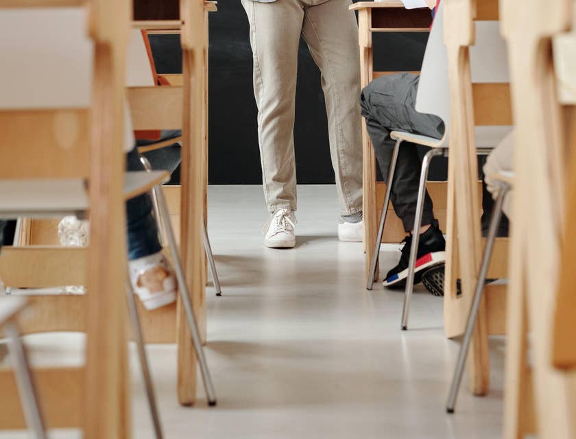 Examiner stands in the middle of the classroom while students are taking the exam