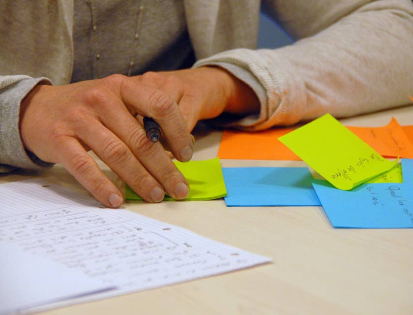 Executive Assistant writing reminders on post-it notes