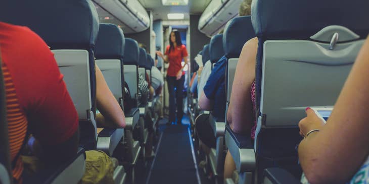Flight attendant conducts pre-flight safety checks.