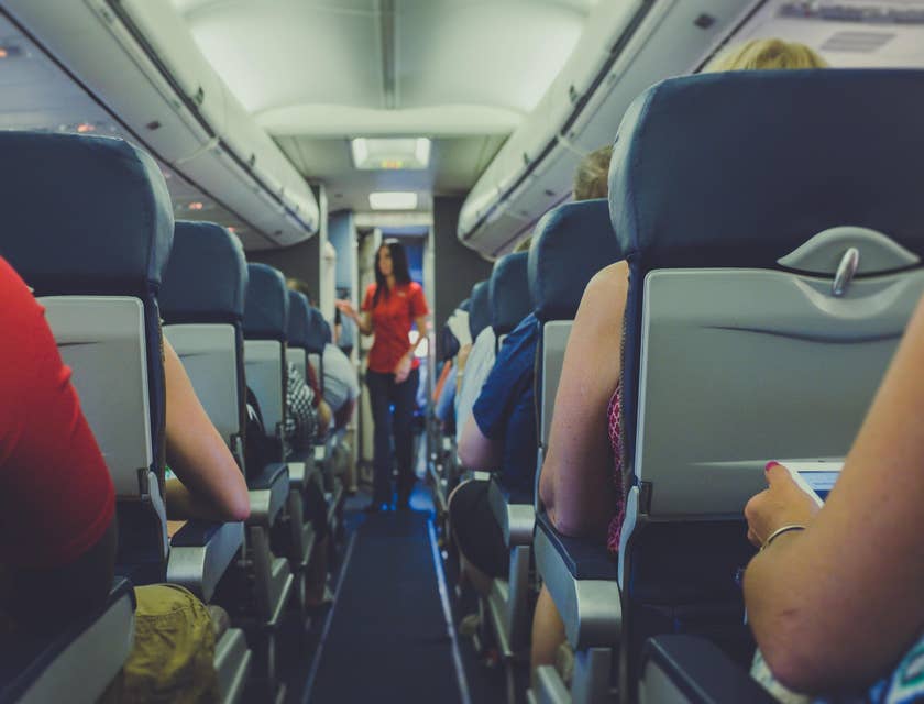 Flight attendant conducts pre-flight safety checks.