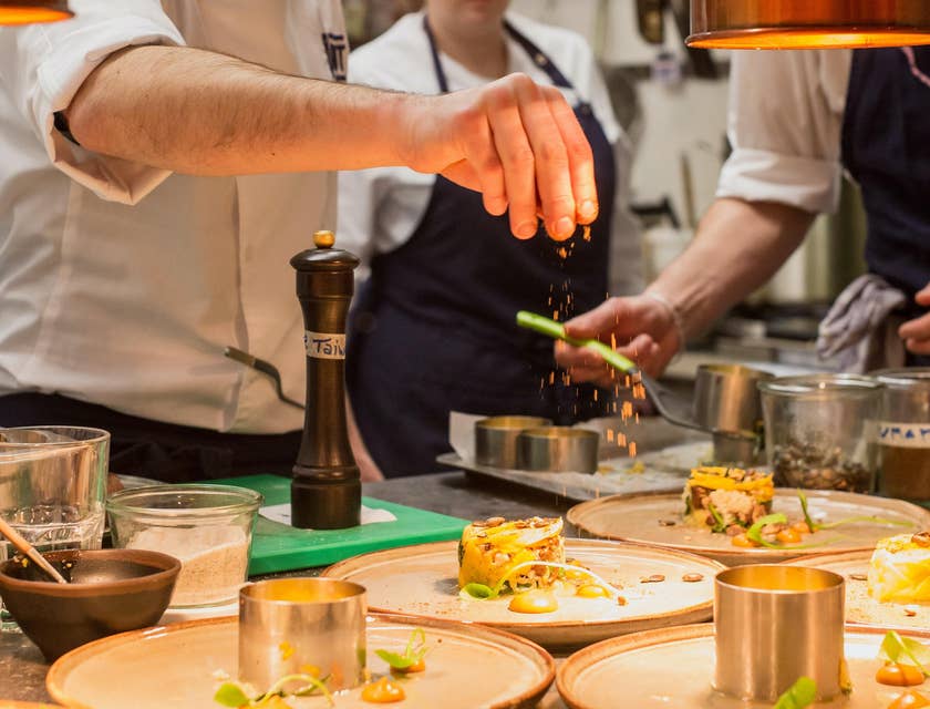 Food expeditor performing the finishing touches to completed dishes.