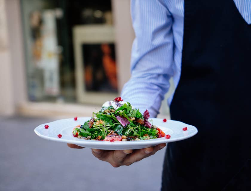 Food Service Worker serving a salad to the customer.