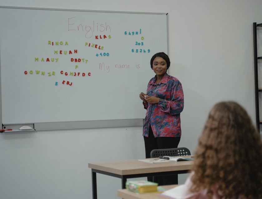 High School English Teacher looks at a student while teaching Spelling using magnetic alphabets