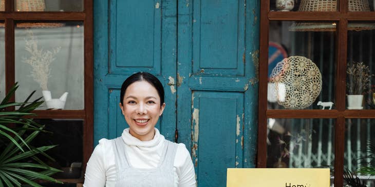 A hostess standing outside a restaurant ready to greet guests.