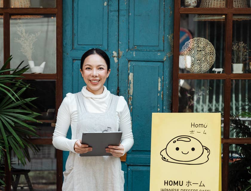 A hostess standing outside a restaurant ready to greet guests.