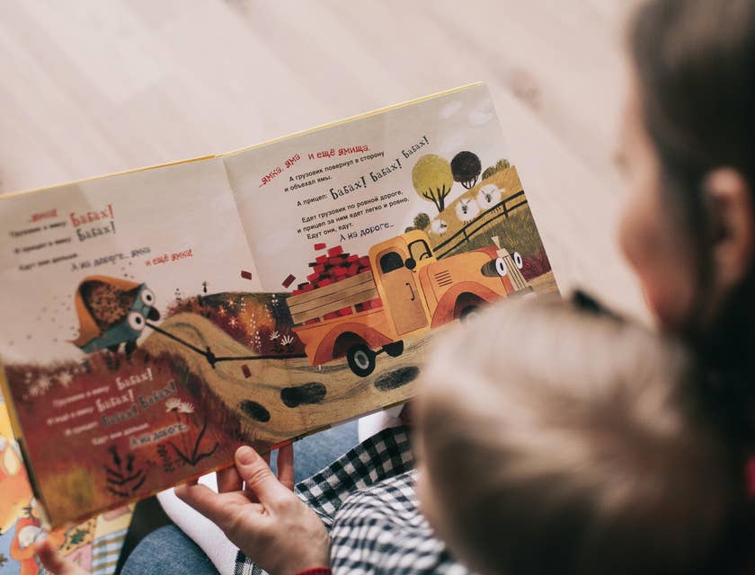 Infant Teacher reads a book about trucks to a toddler
