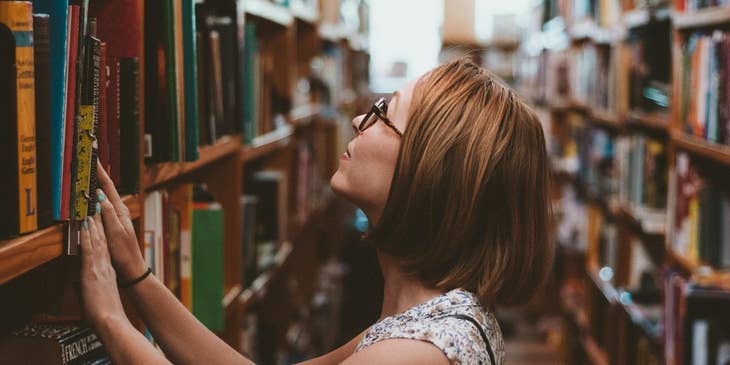 Library clerk re-shelving books