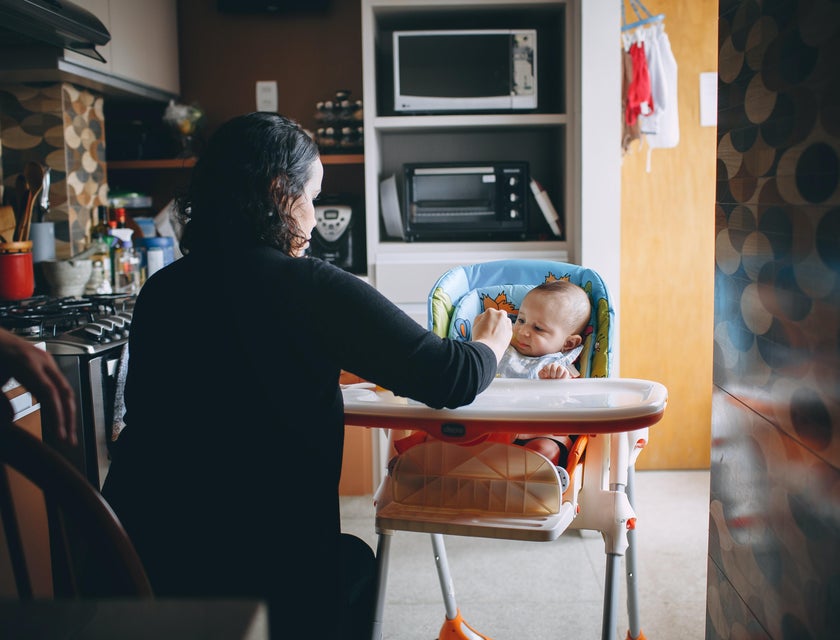 Nanny feeding a baby in the kitchen