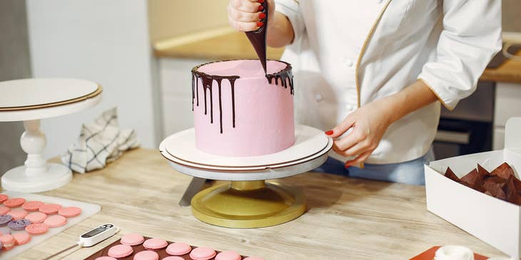 Pastry chef decorating a cake.