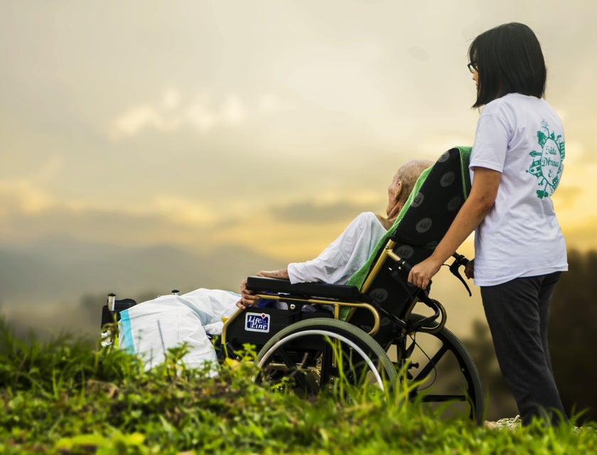 Patient sitter assists the patient in a wheelchair as they went out for a stroll
