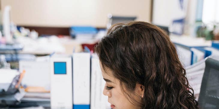 Payroll accountant updating ledger entries while preparing for a payroll report