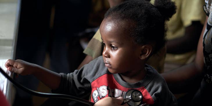 Pediatric cardiologist monitors the baby's heart using a stethoscope