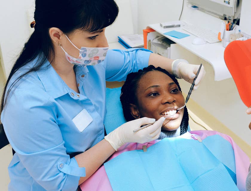 Periodontist shows a patient results after dental treatment using a mirror