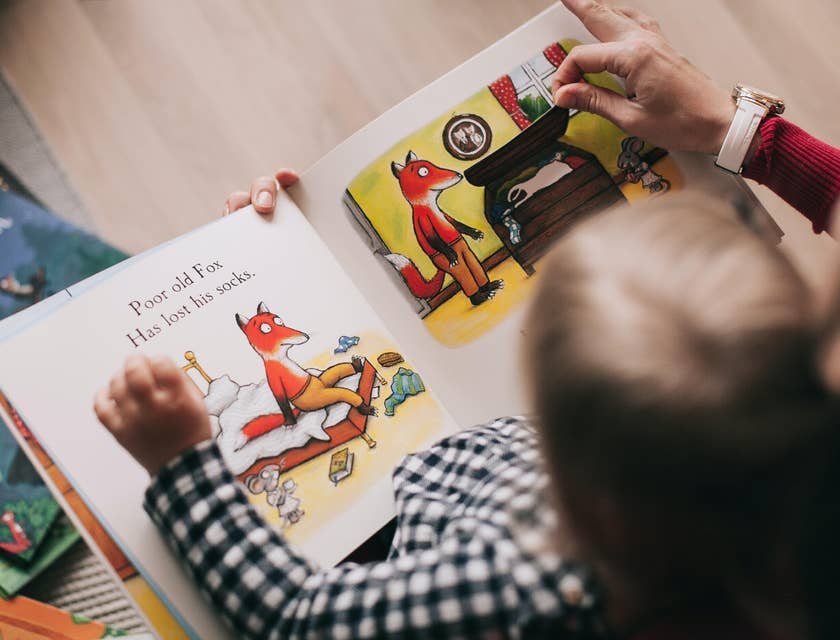 Preschool teacher reading an interactive storybook to a toddler
