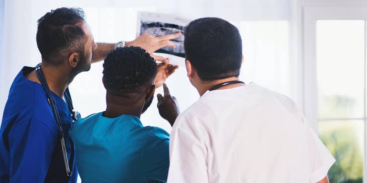 Radiation therapist evaluates Xray results with colleagues to determine treatment