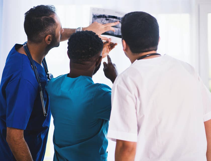 Radiation therapist evaluates Xray results with colleagues to determine treatment