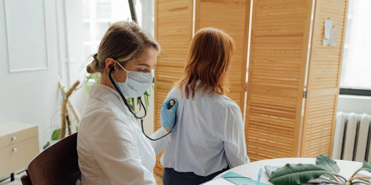 Registered medical assistant records vital signs of the patient while using a stethoscope