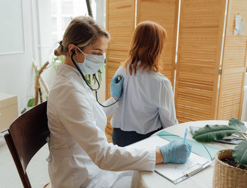 Registered medical assistant records vital signs of the patient while using a stethoscope